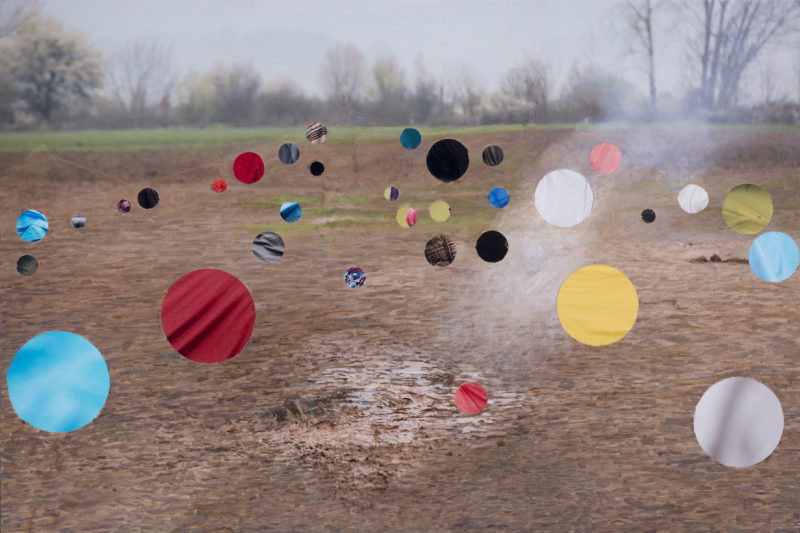 Gekleurde bollen zijn op een persfoto geschilderd van een landschap, door Celine Van Den Boorn