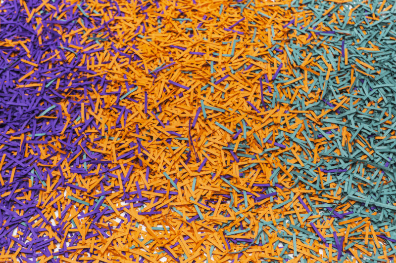 Close-up van de gekleurde papiersnipper die de vloer van de museumzaal bedekken