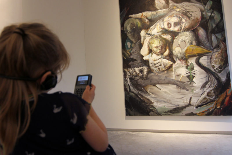 museumbezoeker bekijkt schilderij met gebruik van audiotour