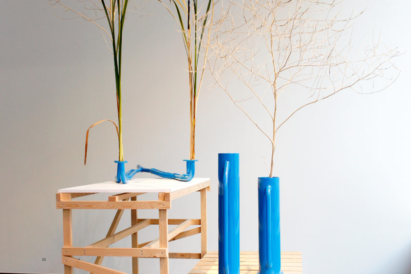 Houten installatie met daarop blauwe vlazen met daarin palmbladeren, door Frank Bruggeman