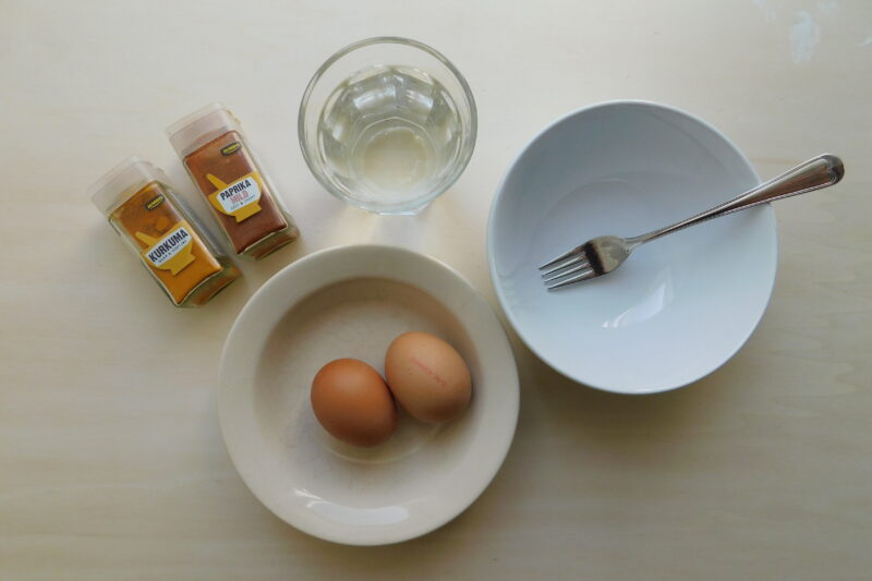 Alle benodigdheden: eieren, mengkommetjes, een vork, water, en kruiden om verschillende kleuren mee te mengen