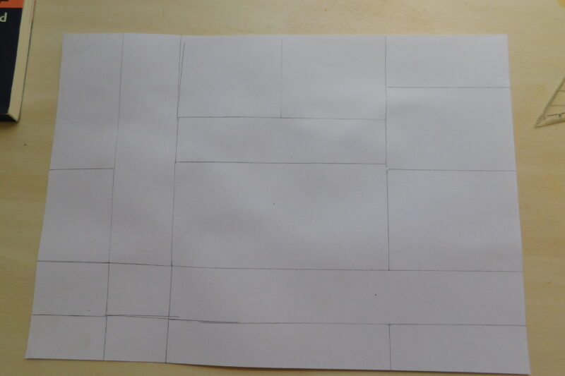 Een wit vel papier met daarop een vlakverdeling aangegeven in grijs potlood