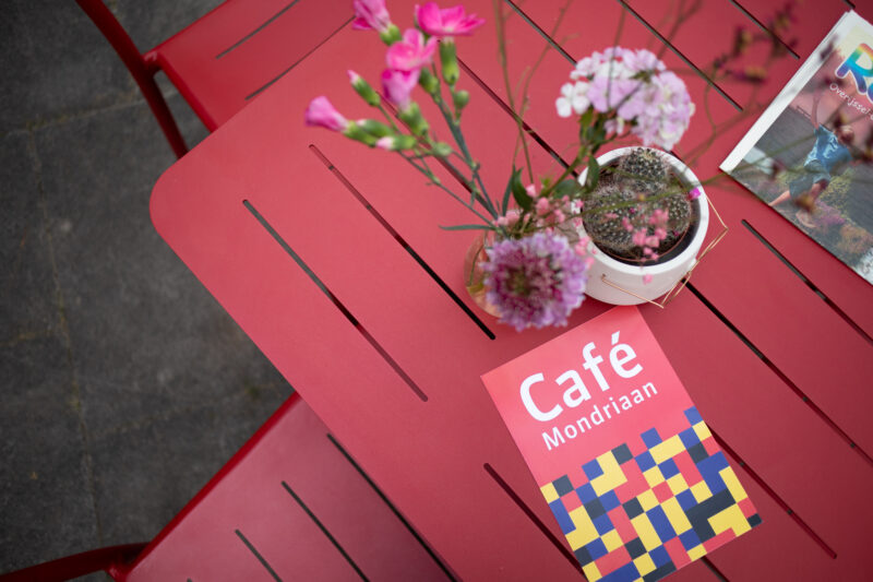 Café Mondriaan menukaart op rode tafel